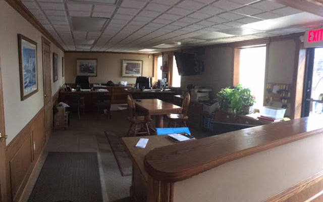 The image shows an interior space with a long counter and a row of chairs on either side.